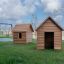 Nature Playhouse venkovní dřevěné herní domečky s houpačkami v pozadí.