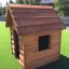Dřevěný Nature Playhouse na umělé trávě.