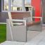 Moderní venkovní Chicago Bench s betonovým a dřevěným designem poblíž vstupu do budovy.