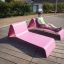 Muž odpočívající venku na růžovém Lounge Sofa.
