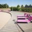Růžové Lounge Sofa židle na promenádě u pláže.