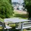 Venkovní Table & Bench Quadro HPL umístěný v zelené parkové scenérii.