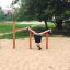 Dítě visící hlavou dolů na herních prvcích Somersault Triple na hřišti.