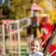 Dítě používající Safety Seat Single Swing na hřišti.