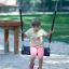 Dítě sedící na Safety Seat Single Swing na hřišti