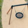 Single Swing (BNS 90cm) houpačka s kruhovým sedadlem a dřevěnou konstrukcí na dětském hřišti.